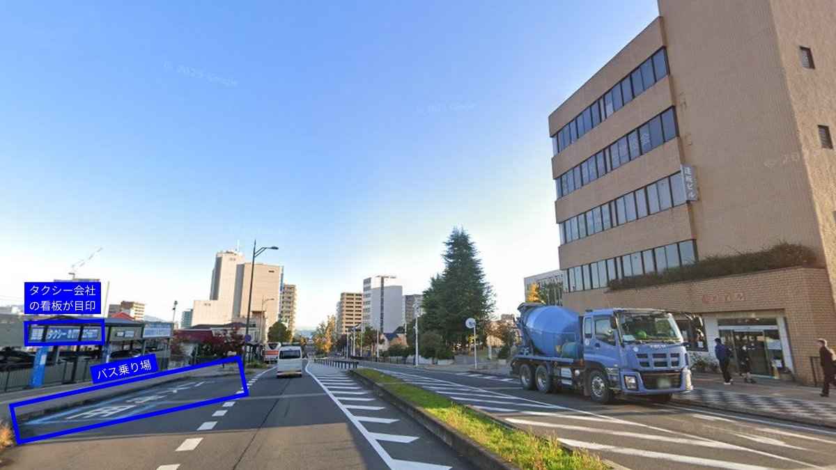 中央大通りを琵琶湖方向に見た風景。左手にバス乗り場の上屋とタクシーの青い看板が並ぶ。